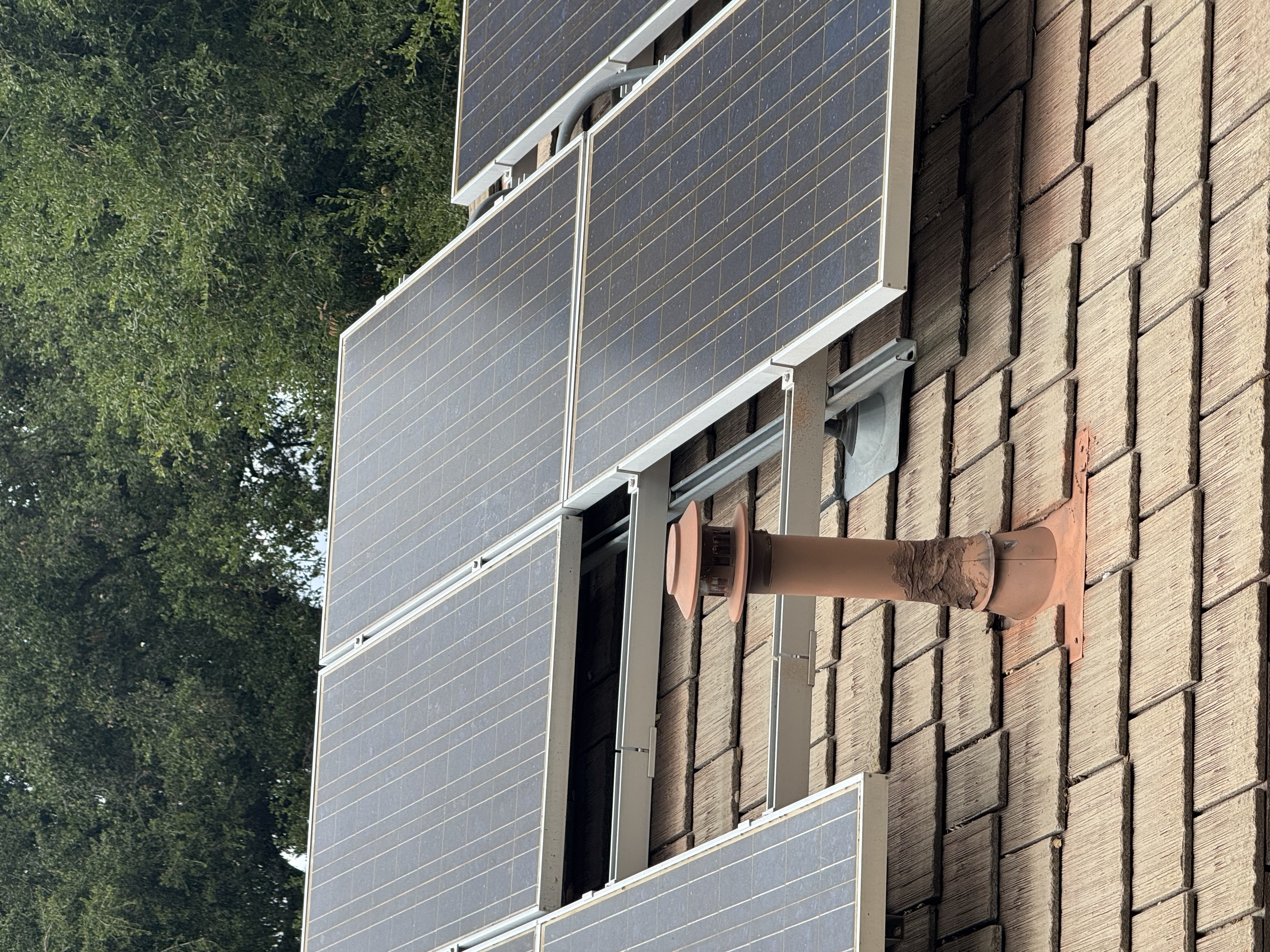 Close detail of solar panel install on residential tile roof.
